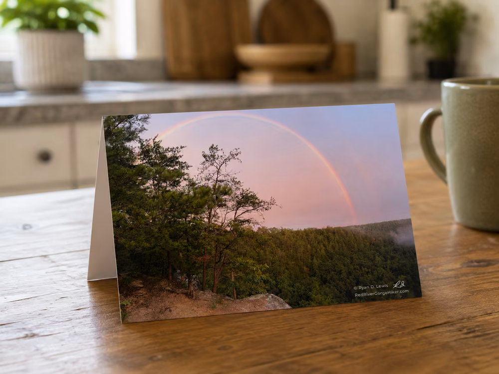 Folded greeting card featuring Double Rainbow at Eagle’s Point Buttress displayed on a wooden table.