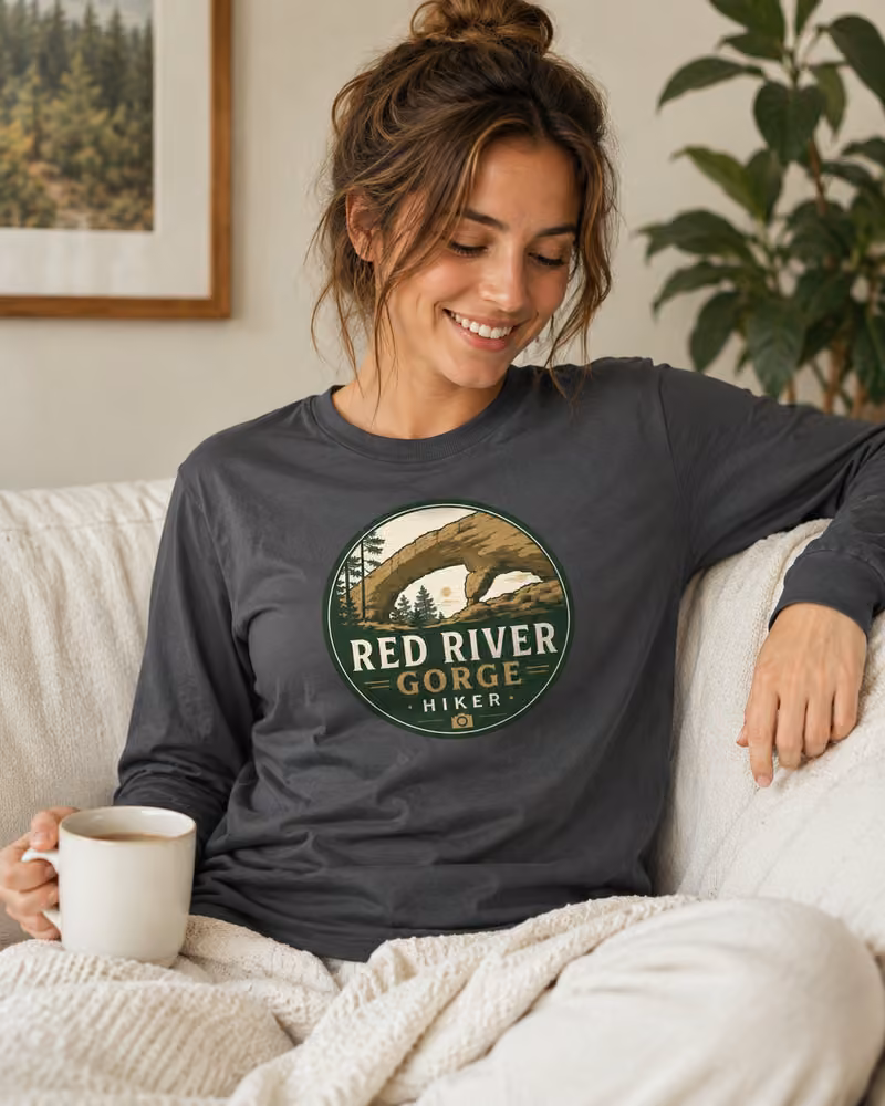 Woman wearing a charcoal Red River Gorge Hiker long-sleeve T-shirt with the logo centered on the chest.