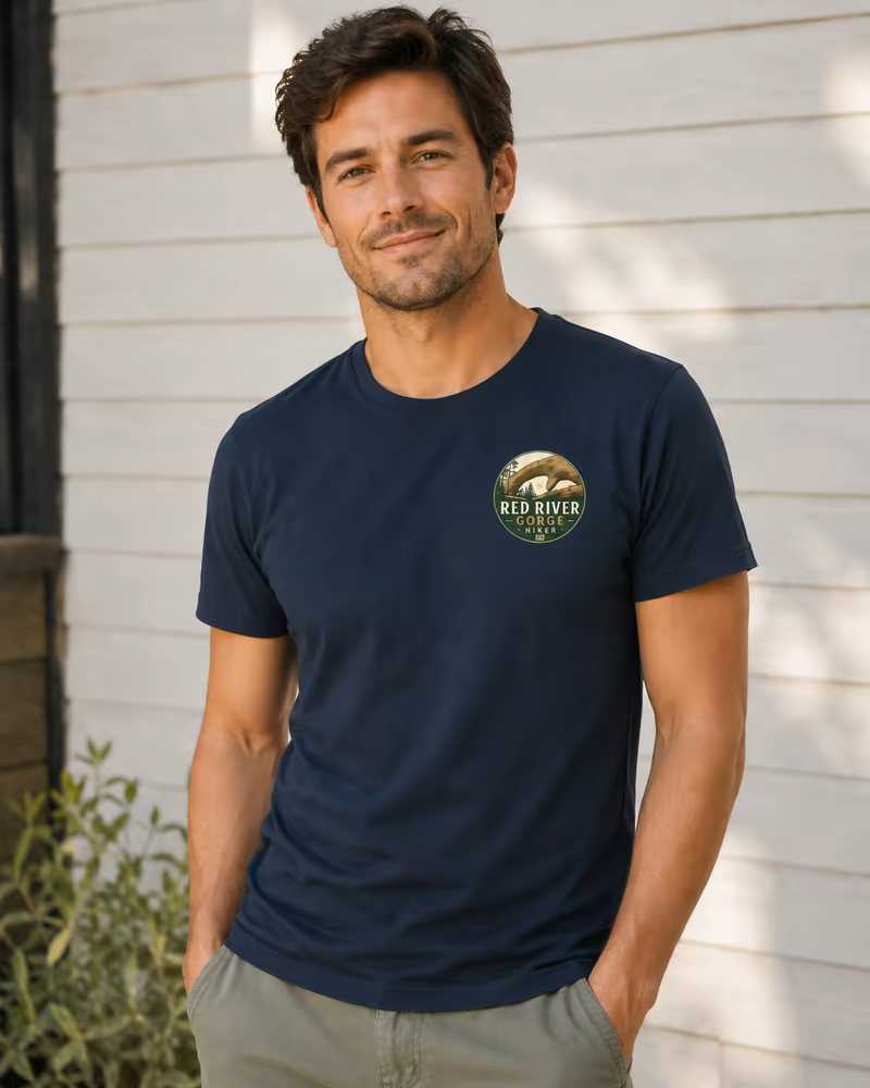Man wearing a navy athletic-fit T-shirt with a small Red River Gorge Hiker logo at the pocket position.